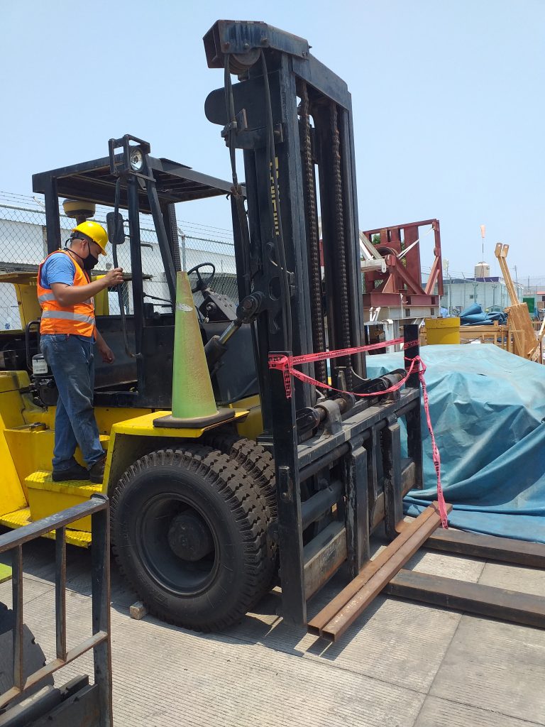 Técnico junto a un montacargas